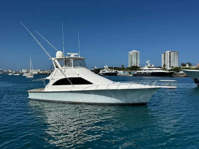 Slide: The Image of Ocean Yachts 48 Convertible 2000 model in a marina with city skyline background. - 12