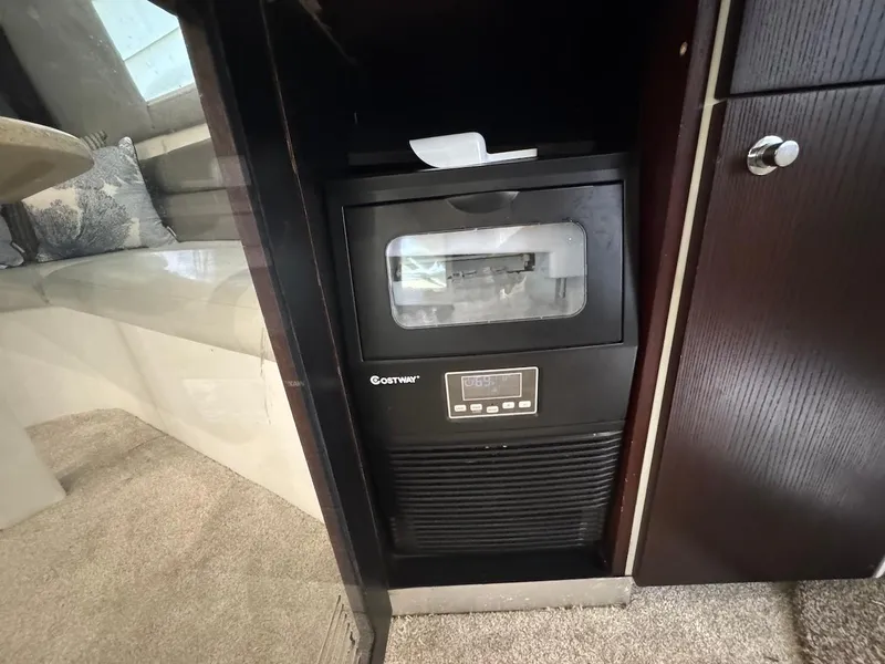 Slide: The Image of Ice maker inside 2000 Ocean Yachts 48 Convertible, with dark wood cabinetry. - 17