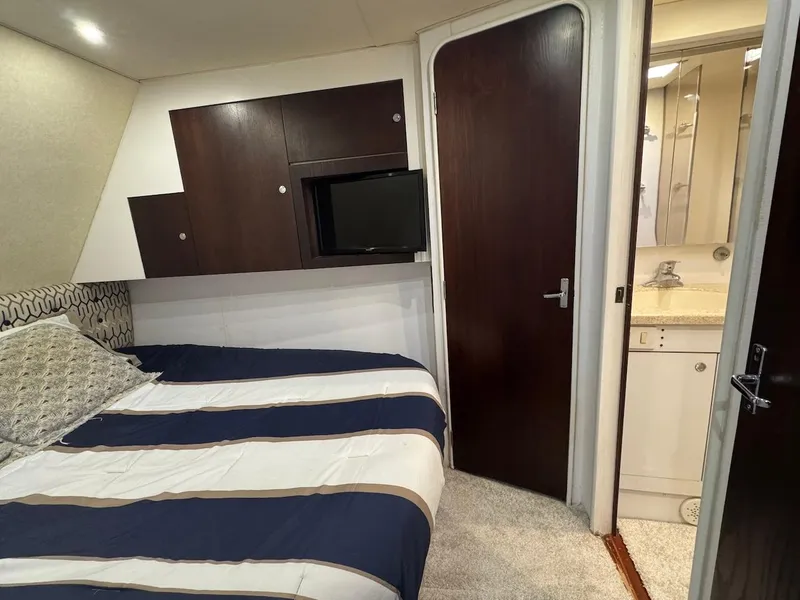 Slide: The Image of 2000 Ocean Yachts 48 Convertible cabin with bed, TV, and ensuite bathroom. - 27