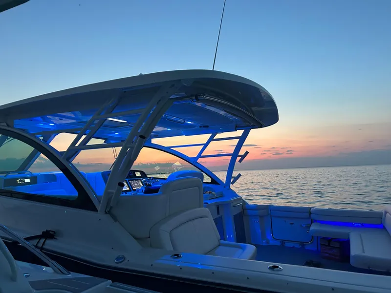 Slide: The Image of 2019 Grady-White Freedom 375 boat at sunset, featuring blue interior lighting. - 12