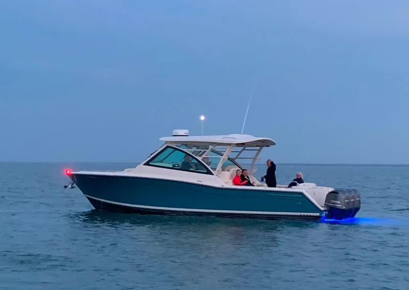 Slide: The Image of 2019 Grady-White Freedom 375 boat on calm water at dusk. - 14