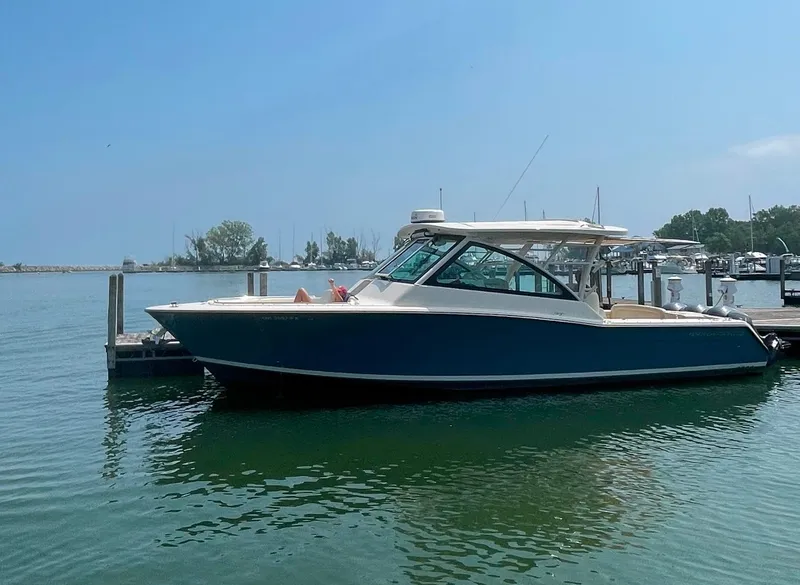 Slide: The Image of 2019 Grady-White Freedom 375 boat docked in a marina under clear blue skies. - 21