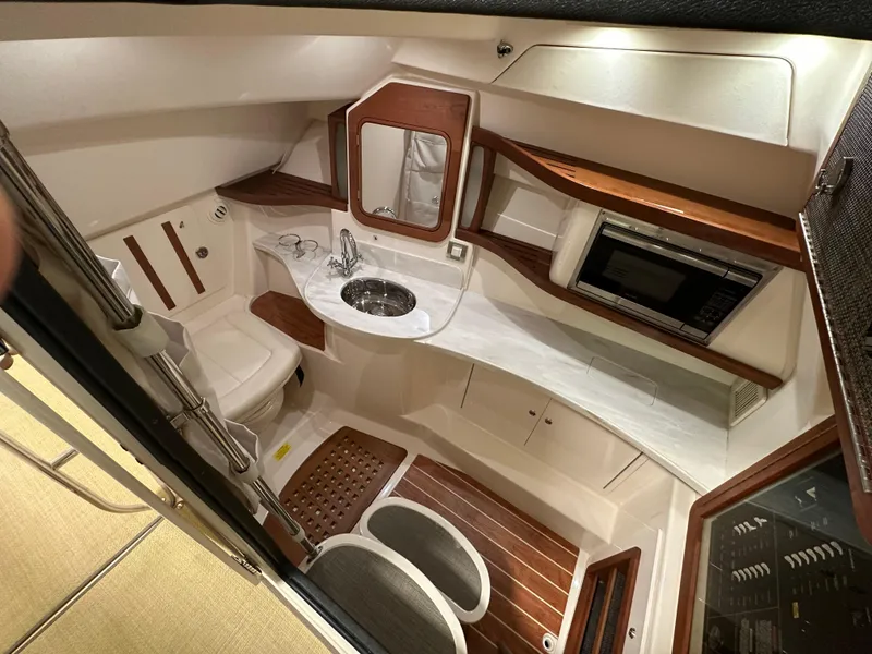 Slide: The Image of 2019 Grady-White Freedom 375 cabin interior with sink, toilet, and microwave. - 32