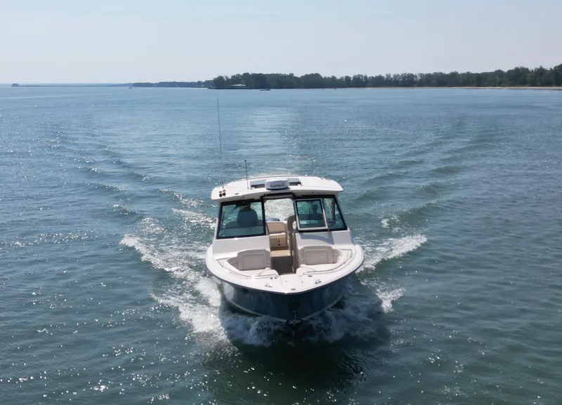Slide: The Image of 2019 Grady-White Freedom 375 cruising on a serene lake with distant shoreline. - 8