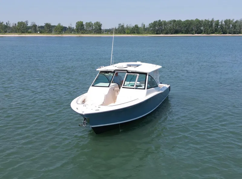 Slide: The Image of 2019 Grady-White Freedom 375 boat on calm water, with distant shoreline. - 9
