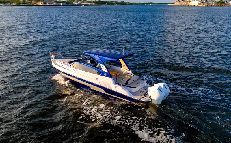 Slide: The Image of 2025 Hanover 305 Outboard Alpine Gray Ultimate Sport Edition cruising on open water. - 21