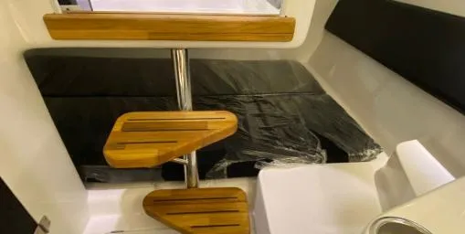 Slide: The Image of Interior of 2025 Hanover 305 Outboard, featuring wooden steps and black seating. - 10