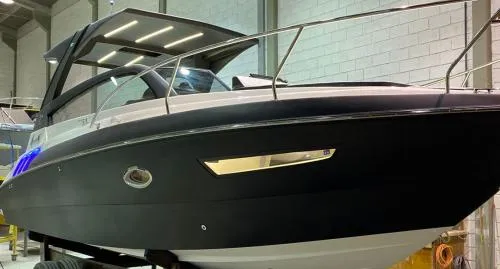 Slide: The Image of 2025 Hanover 305 Outboard Black & White T-Top Edition boat in showroom. - 2