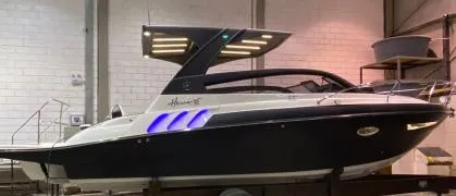 Slide: The Image of 2025 Hanover 305 Outboard Black & White T-Top Edition boat in showroom. - 3