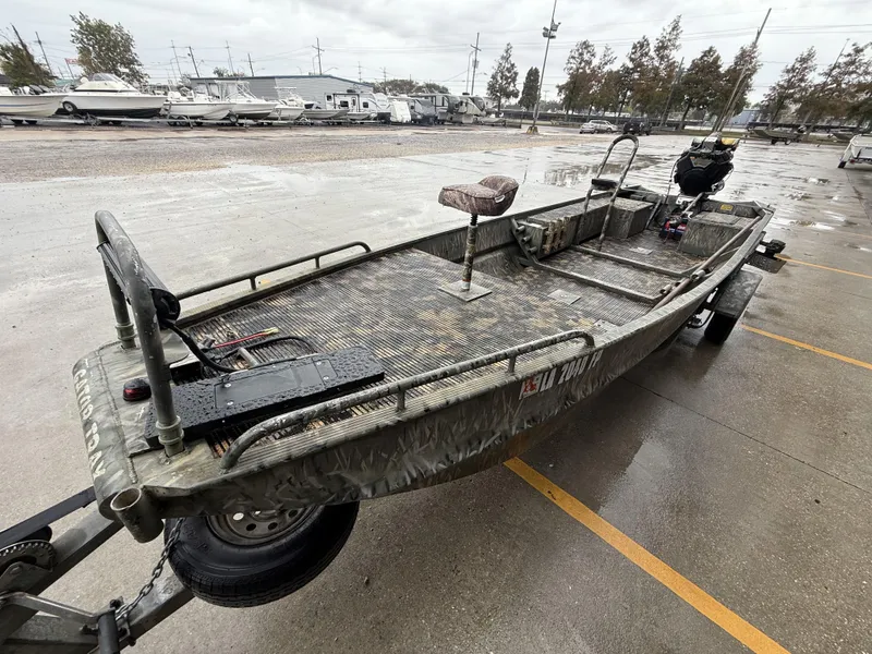 Slide: The Image of 2005 Gator Trax 18 boat on trailer in parking lot, camo design, overcast day. - 1