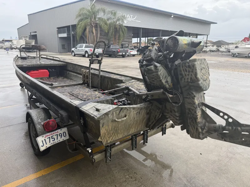 Slide: The Image of 2005 Gator Trax 18 boat on trailer, parked outside a warehouse. - 4
