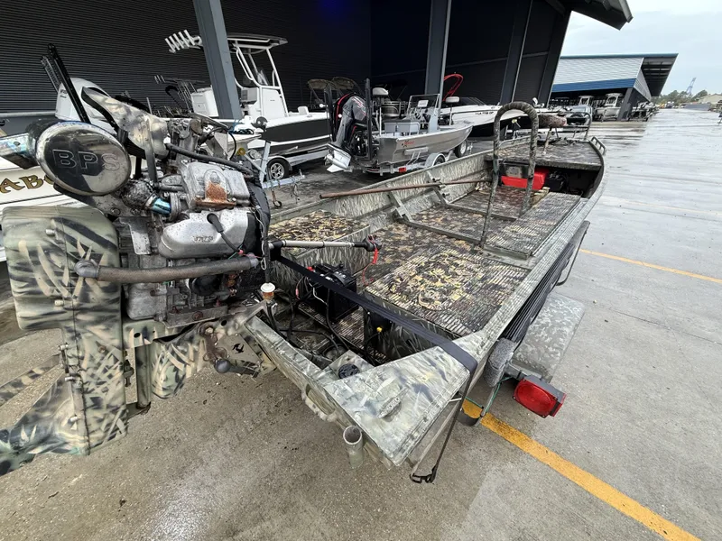 Slide: The Image of 2005 Gator Trax 18 boat with camo design and powerful engine, parked outdoors. - 9