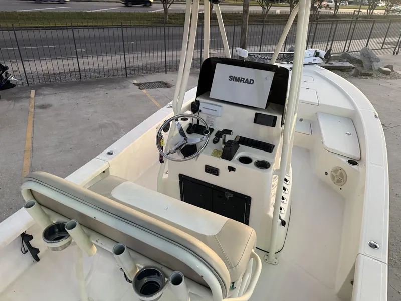 Slide: The Image of 2013 BlackJack 224 boat interior with steering wheel and Simrad navigation system. - 23