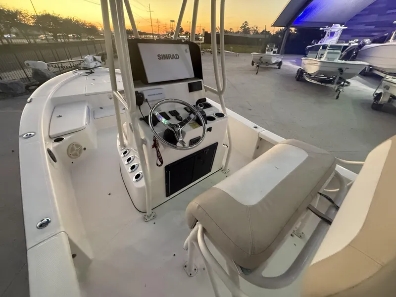Slide: The Image of 2013 BlackJack 224 boat interior with steering wheel and seating at sunset. - 6