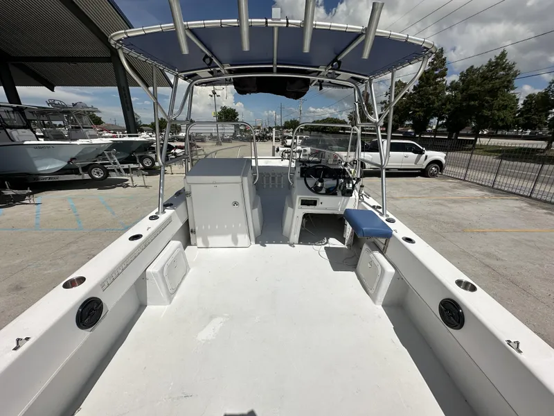 Slide: The Image of 2005 Twin Vee 22 boat interior with seating and steering console, parked outdoors. - 13