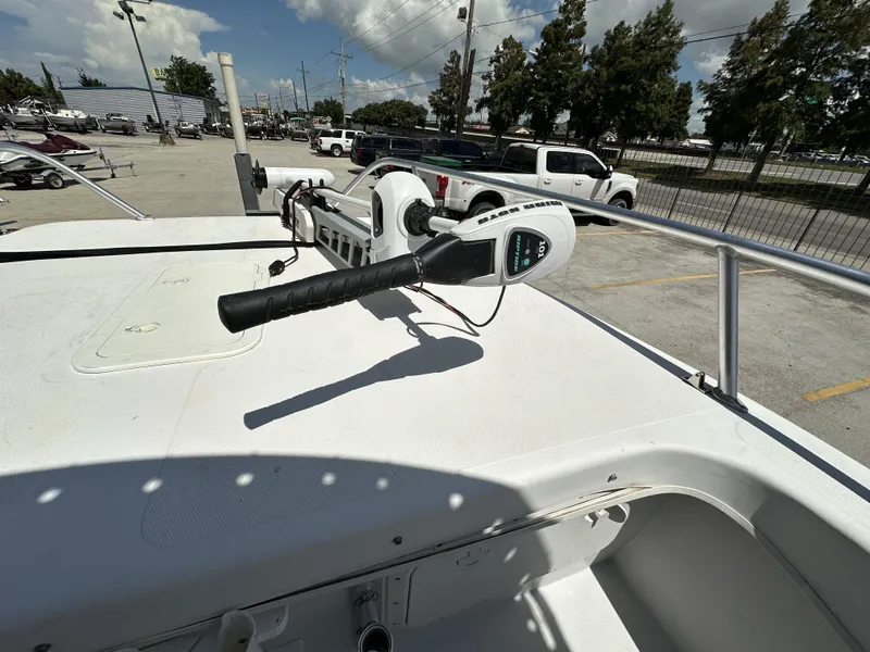 Slide: The Image of 2005 Twin Vee 22 boat deck with trolling motor, parked in a lot under a cloudy sky. - 14