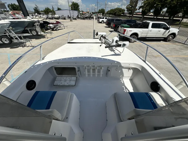 Slide: The Image of 2005 Twin Vee 22 boat interior with seating, parked in a lot with trucks and boats. - 15