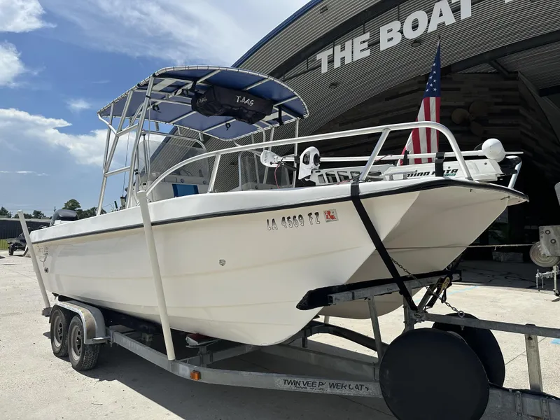 Slide: The Image of 2005 Twin Vee 22 boat on trailer, parked outside a building with an American flag. - 16