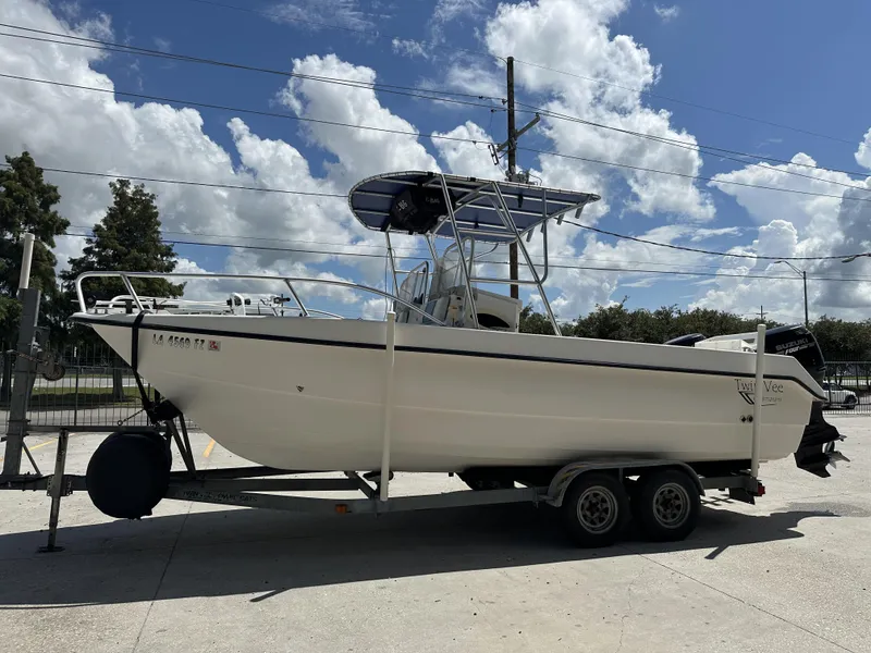 Slide: The Image of 2005 Twin Vee 22 boat on trailer under a partly cloudy sky. - 17