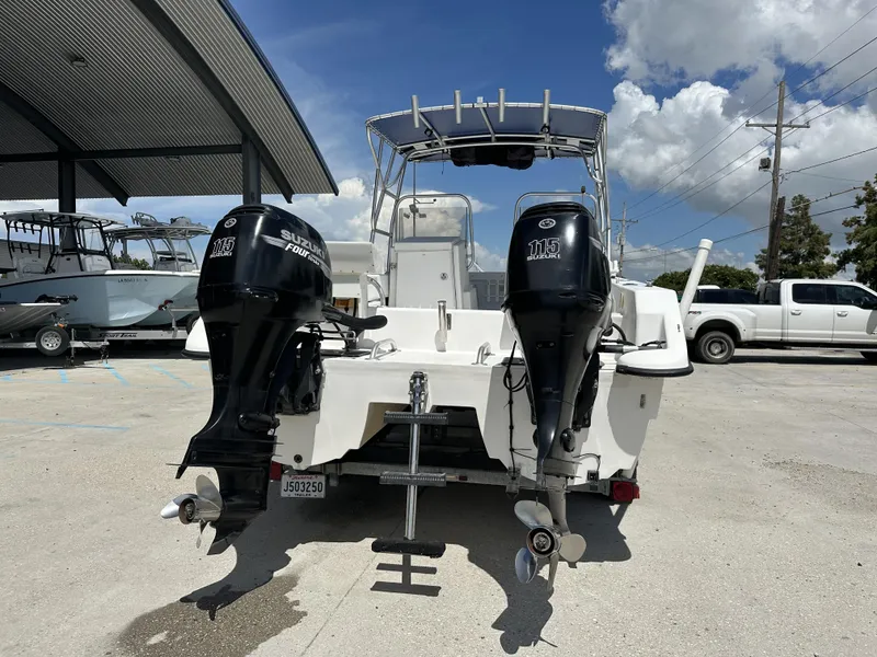 Slide: The Image of 2005 Twin Vee 22 boat with dual Suzuki 115 engines, parked outdoors. - 2