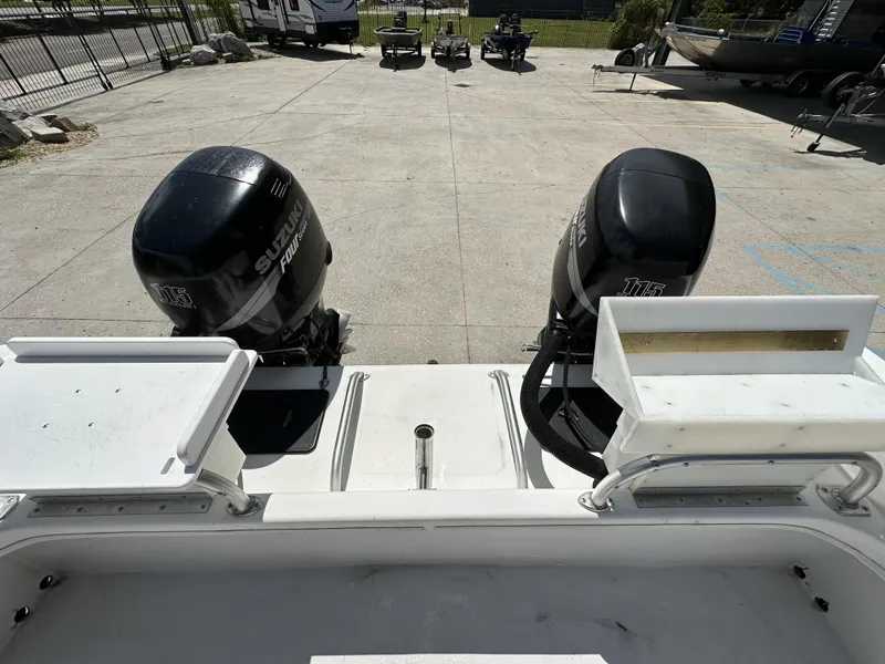 Slide: The Image of 2005 Twin Vee 22 boat with dual Suzuki 115 outboard motors in a parking area. - 4