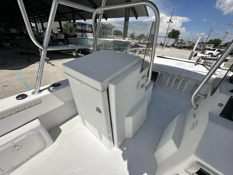 Slide: The Image of 2005 Twin Vee 22 boat interior with storage compartment and railing, docked under shelter. - 9