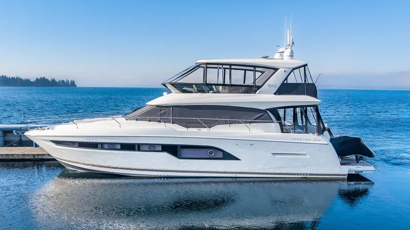 Slide: The Image of 2018 Prestige 630 yacht docked on calm blue water. - 1