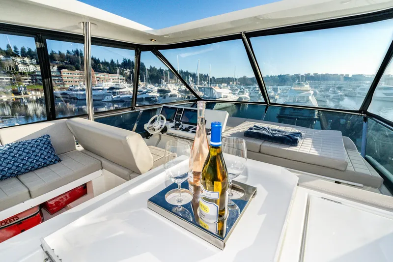 Slide: The Image of Luxurious 2018 Prestige 630 yacht interior with wine bottles, overlooking marina and waterfront views. - 17