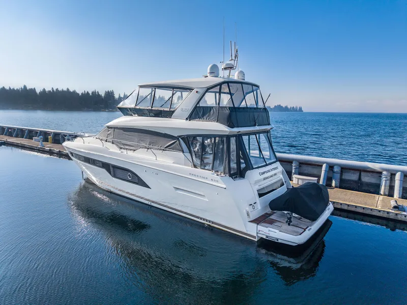 Slide: The Image of 2018 Prestige 630 yacht docked on calm water, clear blue sky background. - 6