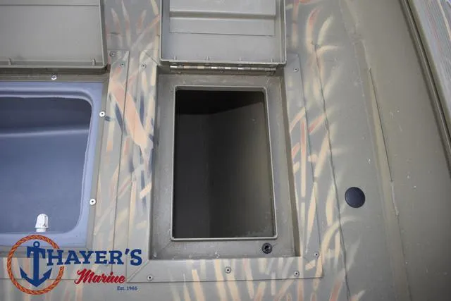 Slide: The Image of 2023 Tracker GRIZZLY® 2072 CC storage compartment, open hatch, Thayer's Marine logo visible. - 17