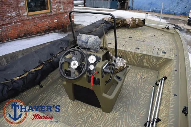Slide: The Image of 2023 Tracker GRIZZLY® 2072 CC boat interior with steering console, camo design, and Thayer's Marine logo. - 29