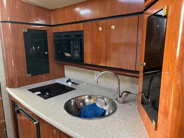 Slide: The Image of 2008 Fountain 38 Sportfish Express Cruiser kitchen with wood cabinets and modern appliances. - 33
