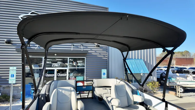 Slide: The Image of 2025 Sylvan A-Series A20 LZ DH pontoon boat with canopy, parked outside dealership. - 10