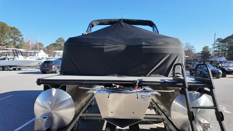 Slide: The Image of 2025 Sylvan A-Series A20 LZ DH pontoon boat with cover in a parking lot. - 16