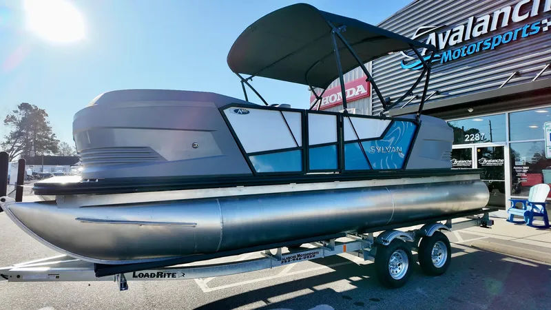 Slide: The Image of 2025 Sylvan A-Series A20 LZ DH pontoon boat on trailer at dealership. - 2