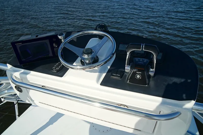 Slide: The Image of 2009 Contender 38 Express helm with steering wheel and controls on open water. - 12