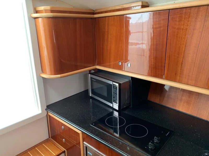 Slide: The Image of 2009 Contender 38 Express kitchen with wooden cabinets, microwave, and electric stove. - 15