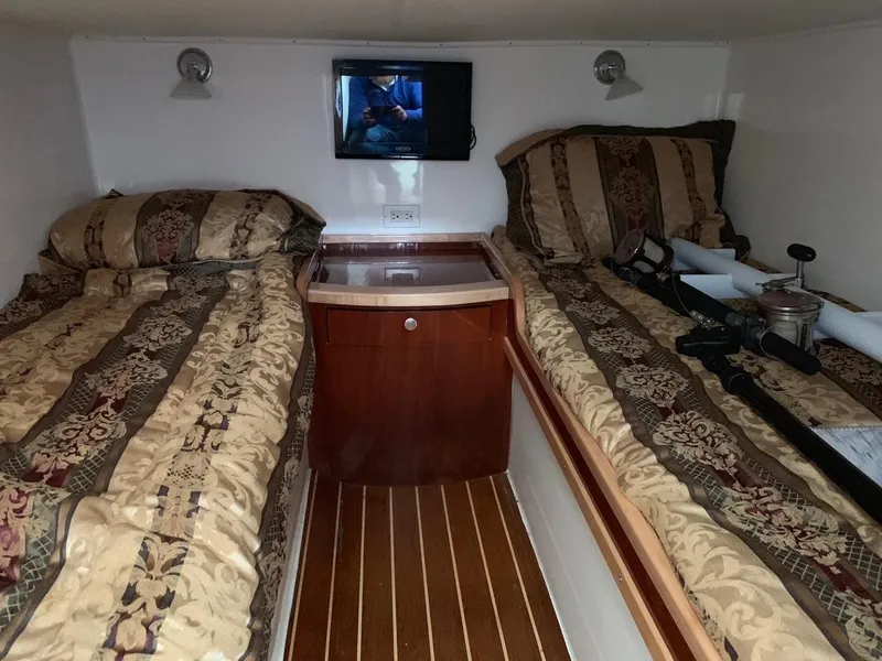 Slide: The Image of 2009 Contender 38 Express cabin with twin beds, TV, and wooden flooring. - 16