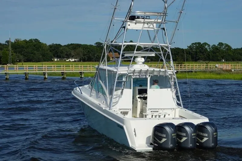 Slide: The Image of 2009 Contender 38 Express boat cruising on a scenic waterway. - 2