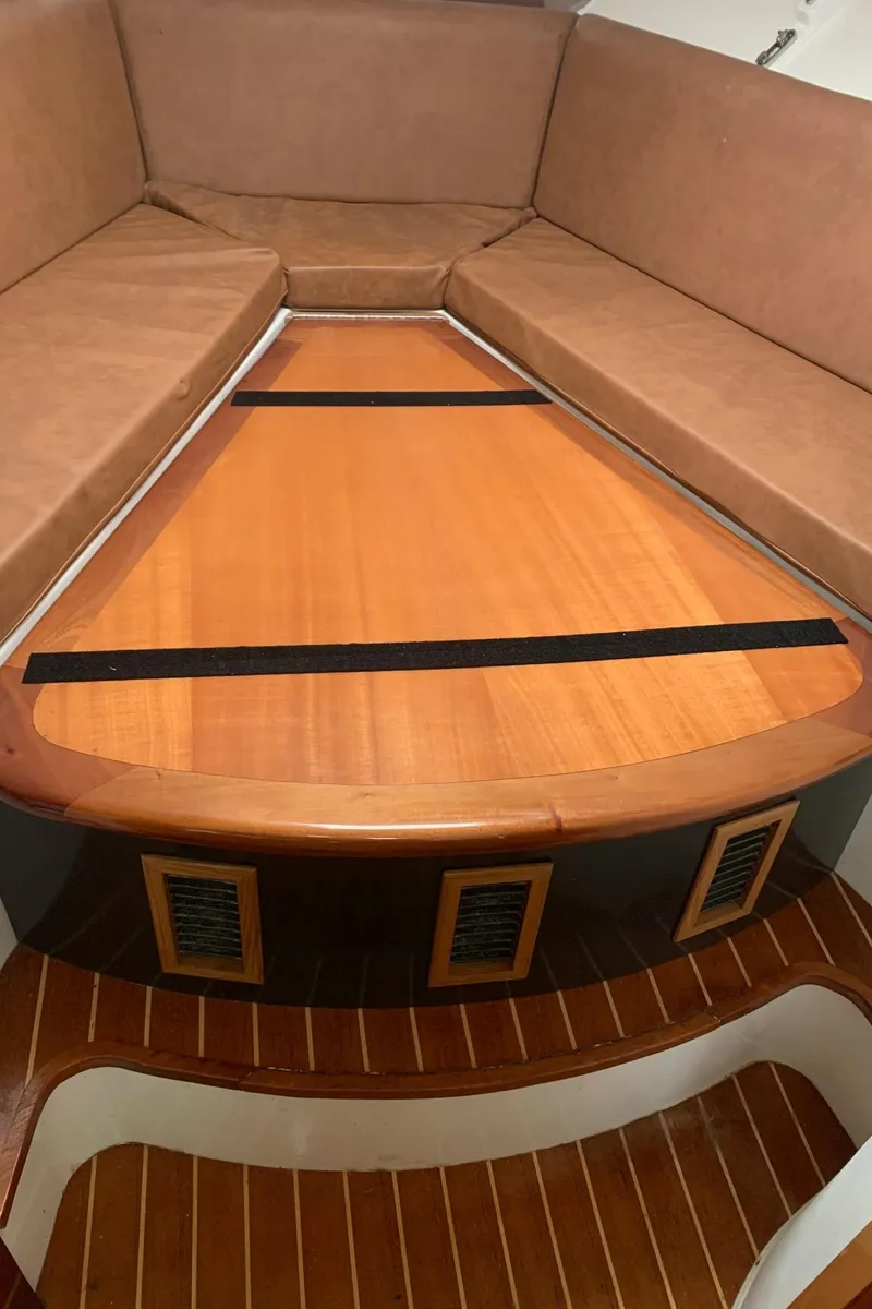 Slide: The Image of 2009 Contender 38 Express cabin interior with wooden table and cushioned seating. - 20