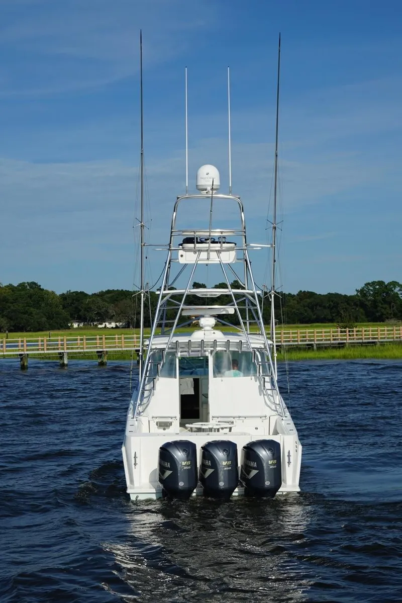 Slide: The Image of 2009 Contender 38 Express boat cruising on a sunny day, with fishing rods and clear skies. - 3