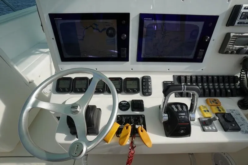 Slide: The Image of 2009 Contender 38 Express boat with triple outboard engines on a calm waterway. - 4