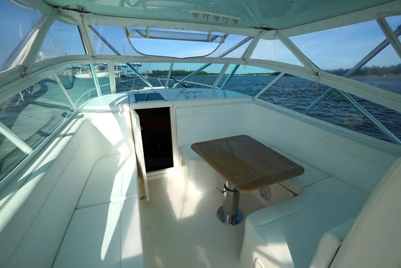 Slide: The Image of 2009 Contender 38 Express boat interior with seating and table, overlooking the ocean. - 8