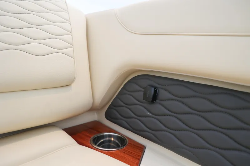 Slide: The Image of 2026 Chris-Craft Sportster 28 interior with beige leather seats and cup holder detail. - 11