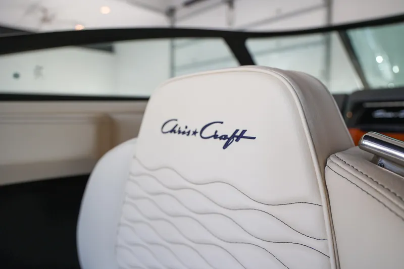 Slide: The Image of 2026 Chris-Craft Sportster 28 boat seat with logo, featuring elegant white upholstery. - 13