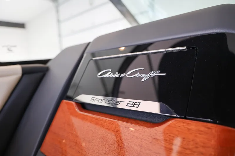Slide: The Image of 2026 Chris-Craft Sportster 28 interior detail with logo and wood finish. - 14