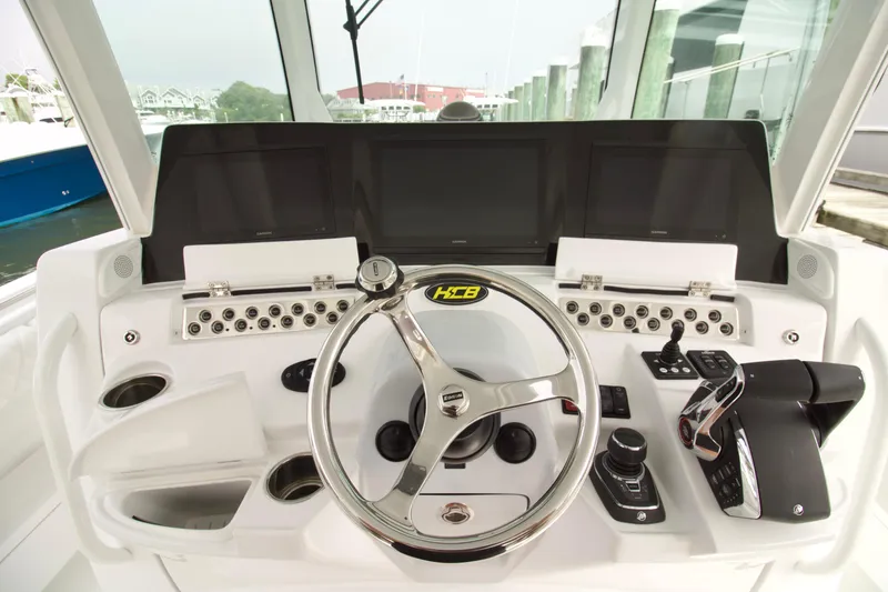 Slide: The Image of Helm of 2026 HCB 42 Lujo boat with modern controls and steering wheel. - 19