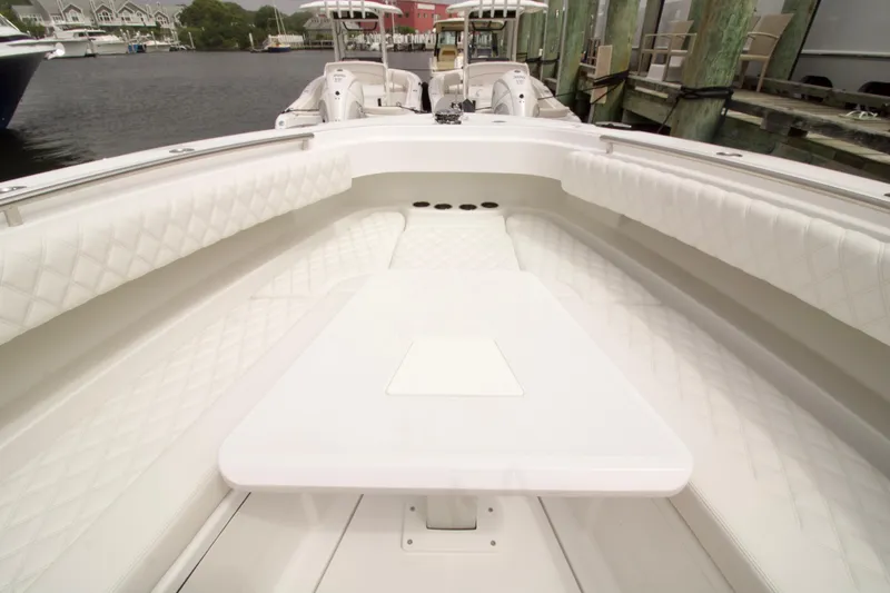 Slide: The Image of 2026 HCB 42 Lujo boat interior with white seating and table, docked at marina. - 25