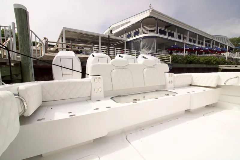 Slide: The Image of 2026 HCB 42 Lujo boat with luxurious white seating at a marina dock. - 27