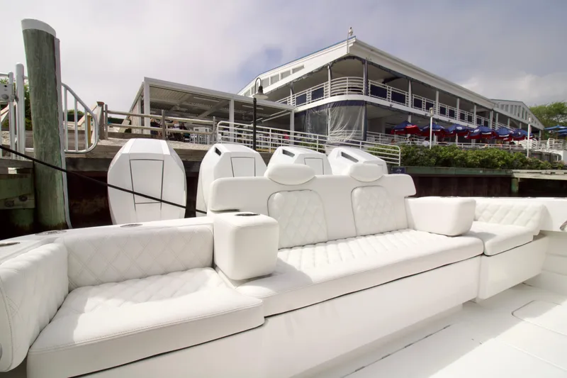 Slide: The Image of Luxurious seating on 2026 HCB 42 Lujo boat docked near waterfront restaurant. - 35